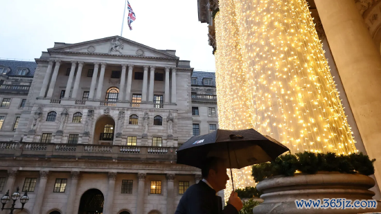 2025 年 12 月 18 日英国伦敦，英国央行货币战略委员会降息当日，又名路东谈主撑伞走过英国央行大楼。